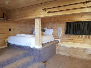 a bedroom with a bed in a log cabin at SKI View 1 in Mount Buller