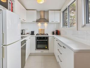 a white kitchen with white cabinets and a stove at SKI View 4 in Mount Buller