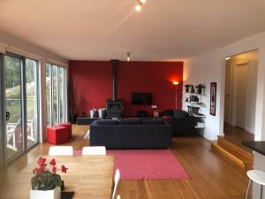 ein Wohnzimmer mit einem schwarzen Sofa und einer roten Wand in der Unterkunft Stirling View in Merrijig