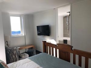 een slaapkamer met een bed en een televisie aan de muur bij Twin Towers 701A in Mount Buller