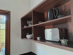 una cocina con estanterías de madera y TV. en RS Beautiful Villa Sanur, en Denpasar