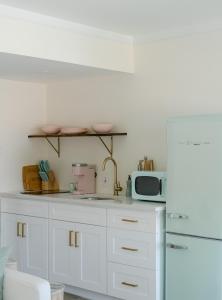 a kitchen with white cabinets and a microwave at The Shore House in Wildwood
