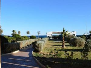 un jardín con un camino y arbustos y un edificio en Appartement Le Lavandou, 2 pièces, 4 personnes - FR-1-251-454, en Le Lavandou