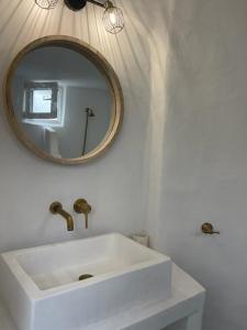 ein Badezimmer mit einem weißen Waschbecken und einem Spiegel in der Unterkunft Lemon House in Hydra