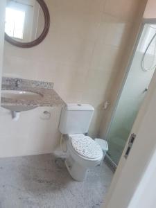 Un baño con inodoro, lavabo y espejo. en Sobrado, en Rio das Ostras 15 fotos más