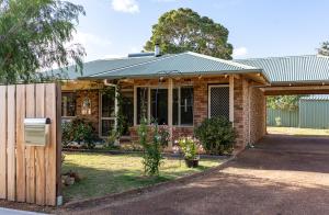 a brick house with a metal roof and a fence at Double J's in Margaret River Town