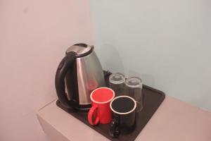 a tray with a tea kettle and cups on a counter at ML SUITES CEBU in Cebu City