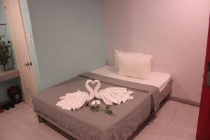 two swans made out of towels sitting on two beds at ML SUITES CEBU in Cebu City