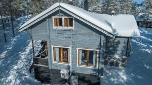ein kleines Haus mit Schnee darüber in der Unterkunft Majatalo Villa in Suomutunturi