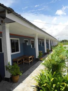 een blauw-wit gebouw met planten ervoor bij Bayu Cenang Inn in Pantai Cenang