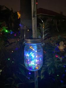 un frasco lleno de luces de Navidad en un jardín en Bayu Cenang Inn, en Pantai Cenang