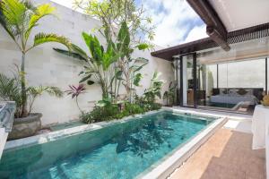 a swimming pool in a villa with plants at Akhyana Village in Jimbaran