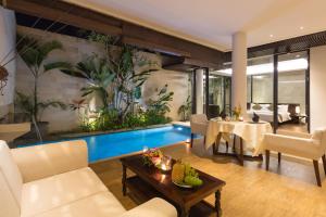 a living room with a swimming pool in a house at Akhyana Village in Jimbaran +80 photos