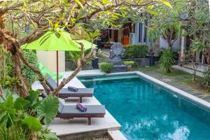 - Piscina con 2 tumbonas y sombrilla en RS Beautiful Villa Sanur, en Denpasar
