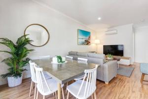 a living room with a table and a couch at MARJ12- Stylish and Spacious in Mooloolaba