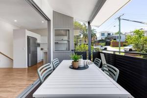 a white table and chairs on the balcony of a house at MARJ12- Stylish and Spacious in Mooloolaba