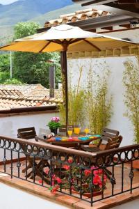 stół i krzesła pod parasolem na patio w obiekcie Hotel Boutique La Española w mieście Villa de Leyva