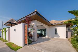 a white house with a driveway at Orchid Paradise Homes OPV422 in Hua Hin