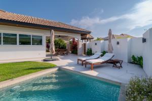 a backyard with a swimming pool and a house at Orchid Paradise Homes OPV422 in Hua Hin