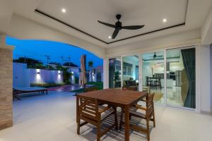a dining room with a table and a ceiling fan at Orchid Paradise Homes OPV422 in Hua Hin