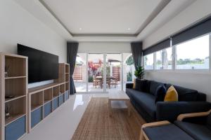 a living room with a blue couch and a tv at Orchid Paradise Homes OPV422 in Hua Hin