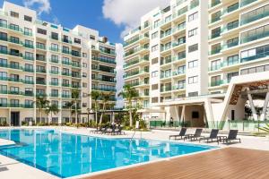 ein Schwimmbad vor einem großen Gebäude in der Unterkunft Luxury Condo, 2BR, Fast Internet, Condo Akul in Playa del Carmen