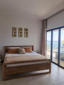 1 dormitorio con 1 cama y vistas al océano en Pieds dans l'eau et spacieux en Rivière Noire