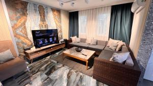 a living room with a couch and a flat screen tv at VILLA KONAK CLUB in Alanya