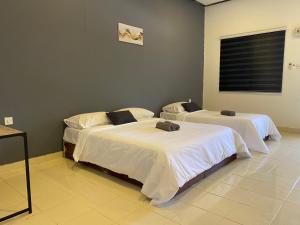 a room with two beds in a room at Bayu Cenang Inn Triple in Pantai Cenang