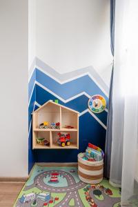 Family Garden Apartments with Free Private Parking & Playground في ريغا: غرفة لعب للأطفال بجدار أبيض وأزرق