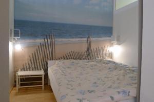 a bedroom with a bed and the beach at Panorama Whg 73, 5 OG in Cuxhaven +22 photos