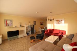 uma sala de estar com um sofá e uma televisão em Panorama Whg 57, 4 OG em Cuxhaven