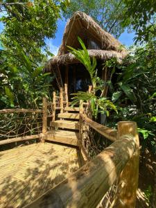 een bamboehut met een trap en een rieten dak bij Inigtan Lio Bamboo Cottages in El Nido