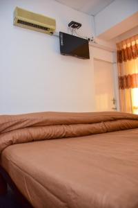 a bedroom with a bed with a television on the wall at Janara Two in Kurunegala