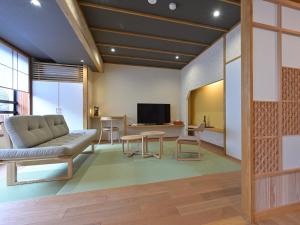 a living room with a couch and a table at Ryokan Tamura in Kusatsu