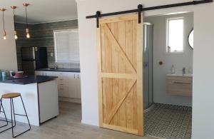 a kitchen with a sliding barn door in a kitchen at Diamond Retreat in Tairua