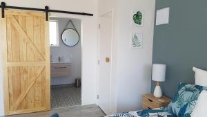 a bedroom with a sliding door leading to a bathroom at Diamond Retreat in Tairua
