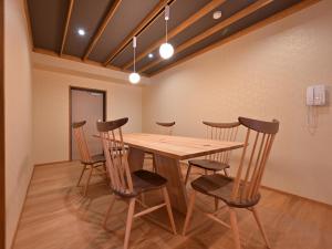 a dining room with a wooden table and chairs at Ryokan Tamura in Kusatsu