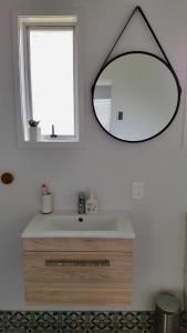łazienka z umywalką i lustrem na ścianie w obiekcie Diamond Retreat w mieście Tairua