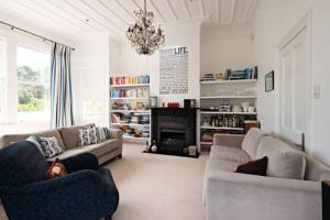 a living room with two couches and a fireplace at Kelburn House at the top of the Cable Car in Wellington