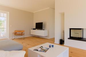 ヴストロにあるHaus am Schilfの白いソファと暖炉のあるリビングルーム