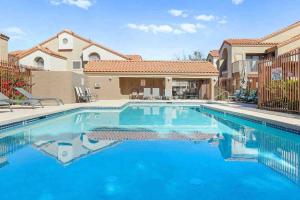 uma piscina em frente a uma casa em The Cool Cactus Condo with Pool and Jacuzzi em Tempe