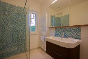 ヴストロにあるHaus am Schilfの洗面台とガラスのシャワーを備えたバスルーム +38枚の写真