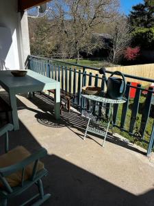 uma mesa com um bule de chá ao lado de uma cerca em Petit paradis dans l'aveyron em Saint-Jean-du-Bruel