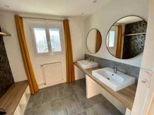uma casa de banho com 2 lavatórios e um espelho em La Terrasse du Port - Front de Mer - 10 Personnes em Port-en-Bessin-Huppain