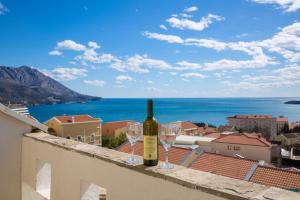 a bottle of wine and two wine glasses on a ledge at Spa Resort Luxury Apartments in Budva
