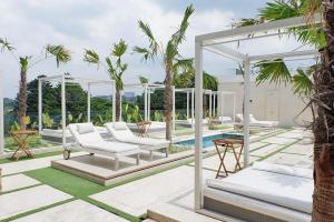 patio con sedie, gazebo e piscina di Deluxe Room @ ArtDeco Luxury Hotel & Residence By Parker House a Bandung