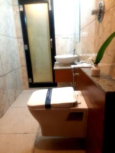 La salle de bains est pourvue de toilettes et d'un lavabo. dans l'établissement Vijay Inn by Unicorn, à Krishnagiri