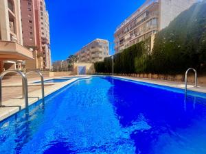 una grande piscina blu in una città con edifici di Beach House by Gloove a Torrevieja