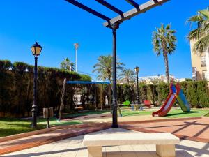 un parco con parco giochi con scivolo di Beach House by Gloove a Torrevieja